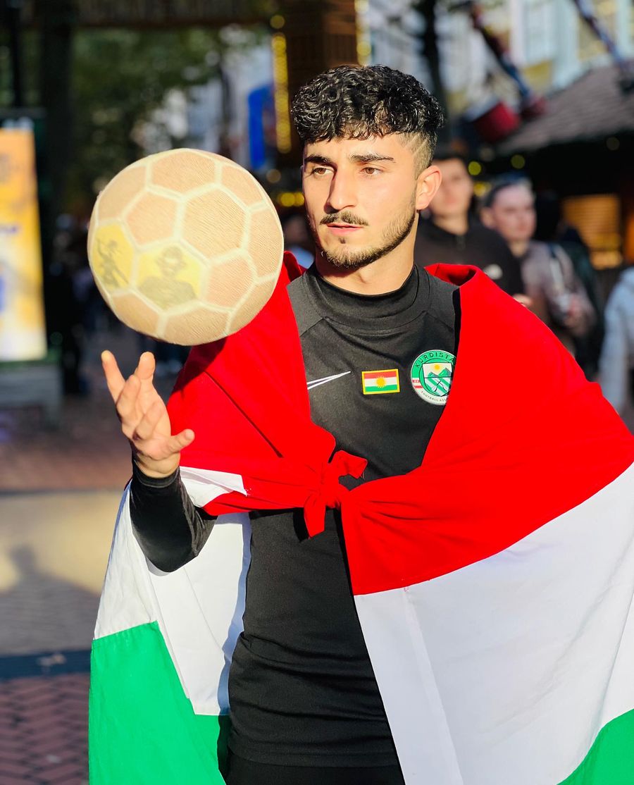 Kurdish freestyler wrapped in the flag, ball in hand